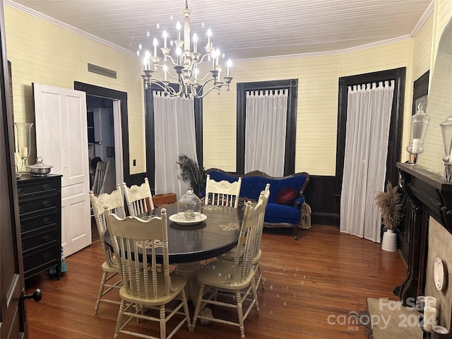 dining room featuring dark hardwood / wood-style floors, crown molding, and a chandelier