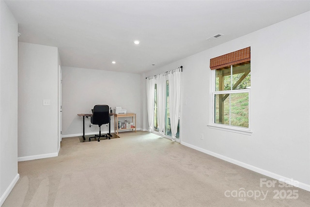 unfurnished office featuring plenty of natural light and light colored carpet