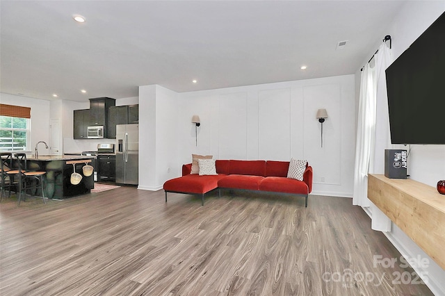 living room featuring sink and dark hardwood / wood-style flooring