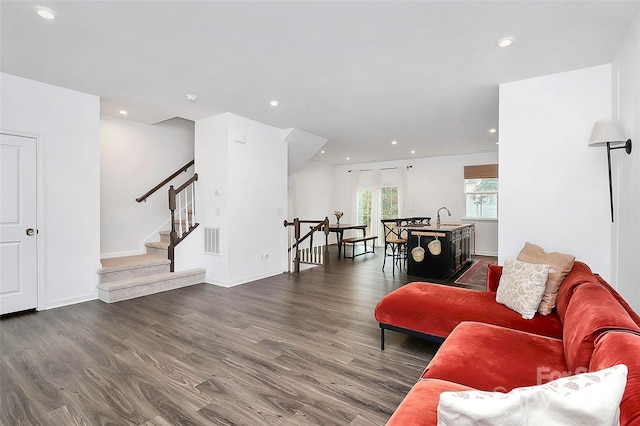 living room featuring sink and dark hardwood / wood-style floors