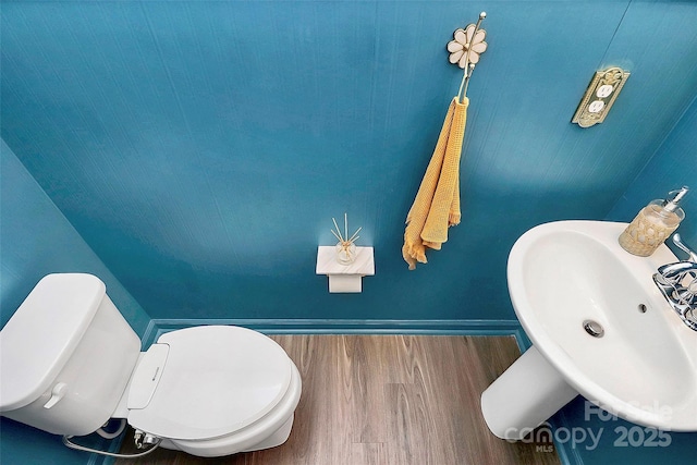 bathroom with hardwood / wood-style flooring, sink, and toilet