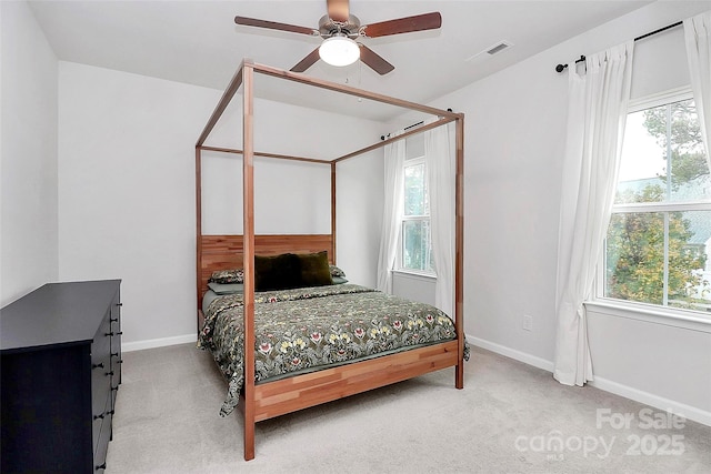 carpeted bedroom with ceiling fan and multiple windows