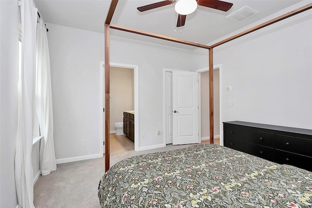 bedroom featuring connected bathroom, light colored carpet, and ceiling fan