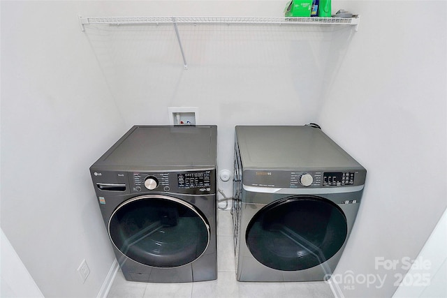 laundry area featuring washer and dryer and light tile patterned floors