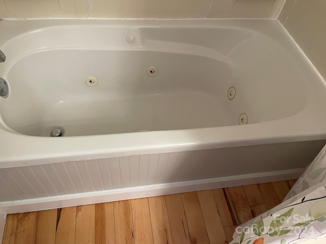 bathroom with a washtub and hardwood / wood-style floors