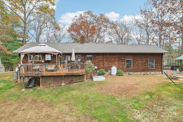 rear view of house featuring a wooden deck, a gazebo, and a yard