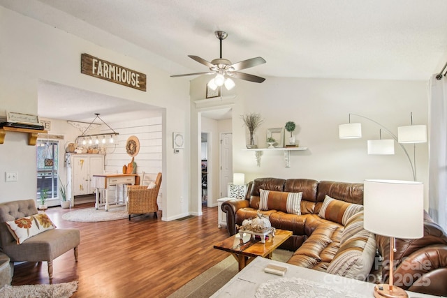 living room with lofted ceiling, wood-type flooring, and ceiling fan with notable chandelier