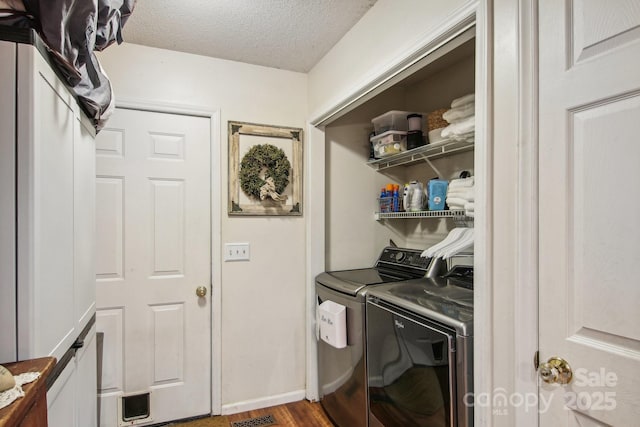 clothes washing area with hardwood / wood-style floors, independent washer and dryer, and a textured ceiling