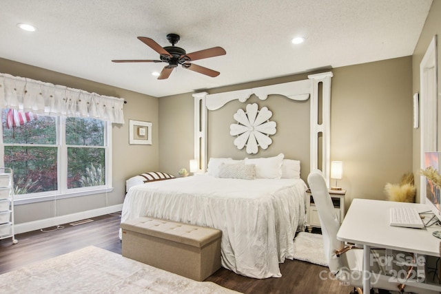 bedroom with ceiling fan, dark wood-type flooring, and a textured ceiling