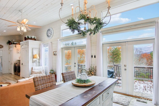 dining space with independent washer and dryer, wood-type flooring, wooden ceiling, and french doors