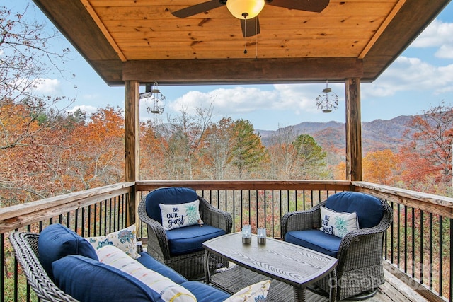 wooden deck featuring a mountain view and ceiling fan