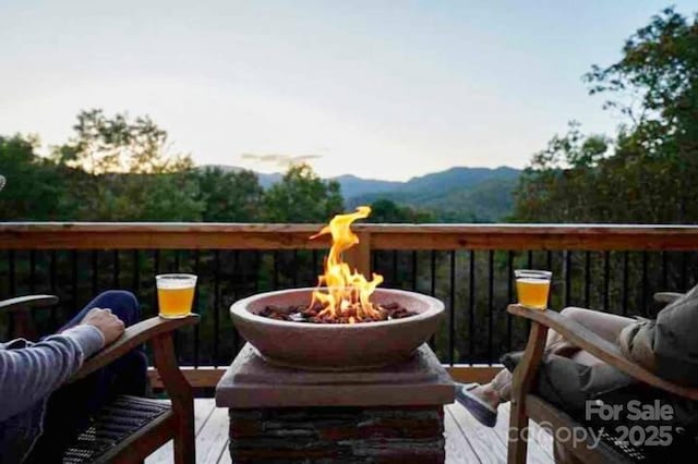 balcony featuring a deck with mountain view and a fire pit