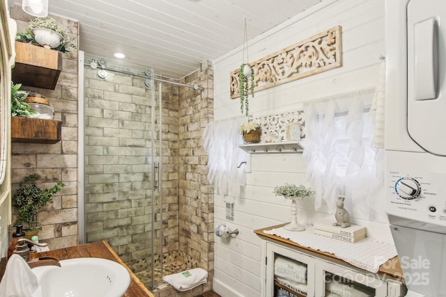 bathroom featuring stacked washer / dryer, sink, an enclosed shower, and toilet