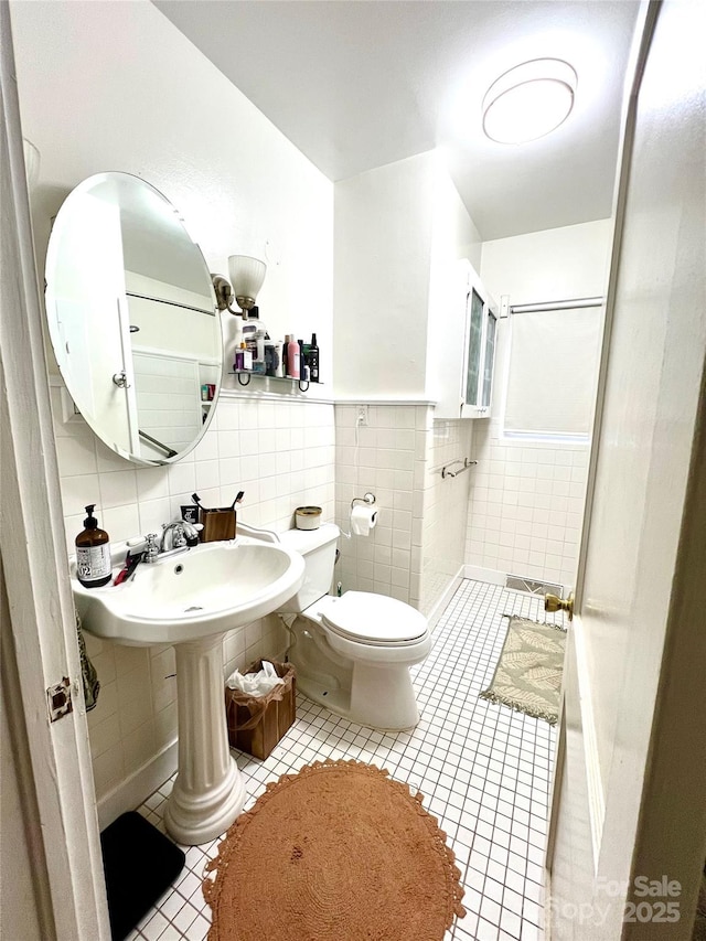 bathroom featuring tile patterned flooring, toilet, tile walls, and tasteful backsplash