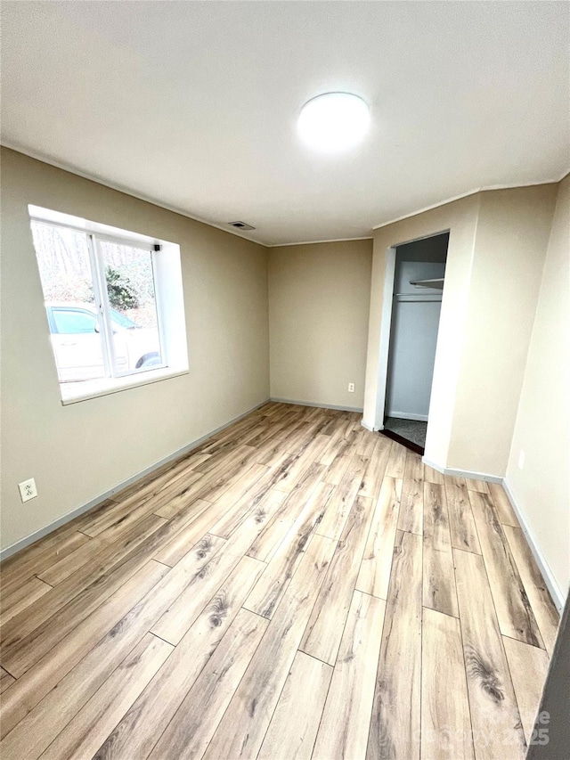 unfurnished bedroom featuring light hardwood / wood-style floors and a closet