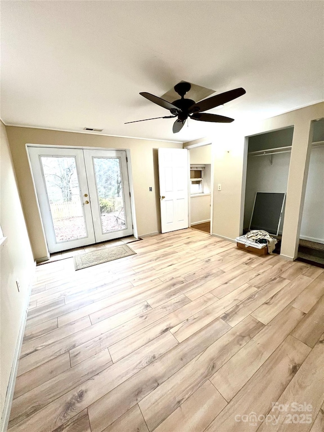 unfurnished bedroom featuring ceiling fan, light hardwood / wood-style floors, and french doors