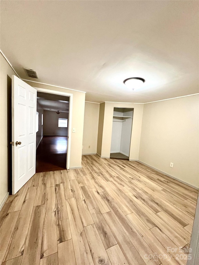 unfurnished bedroom featuring light hardwood / wood-style flooring and a closet