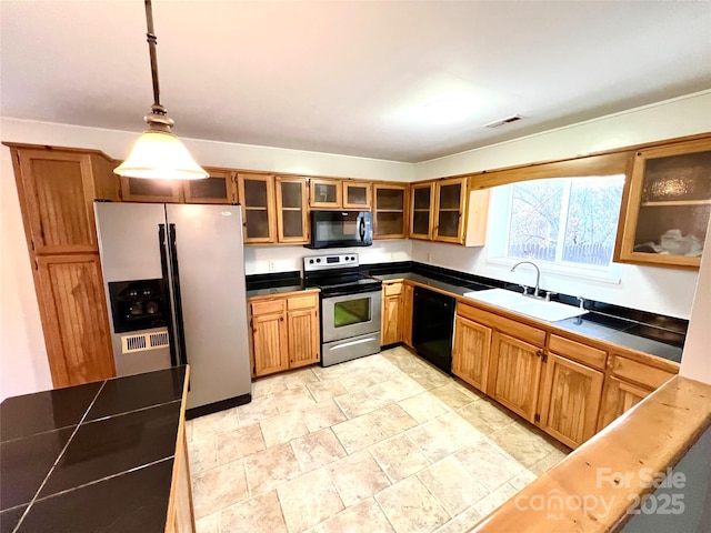 kitchen with black appliances, decorative light fixtures, and sink