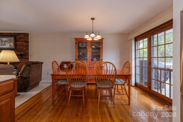 dining room with light hardwood / wood-style floors and a notable chandelier