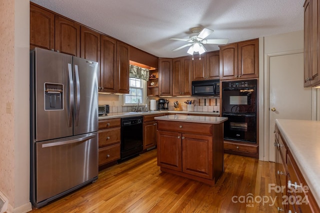 kitchen featuring black appliances, a textured ceiling, sink, ceiling fan, and light hardwood / wood-style flooring