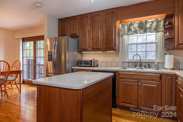 kitchen with stainless steel refrigerator with ice dispenser, light hardwood / wood-style flooring, sink, and plenty of natural light