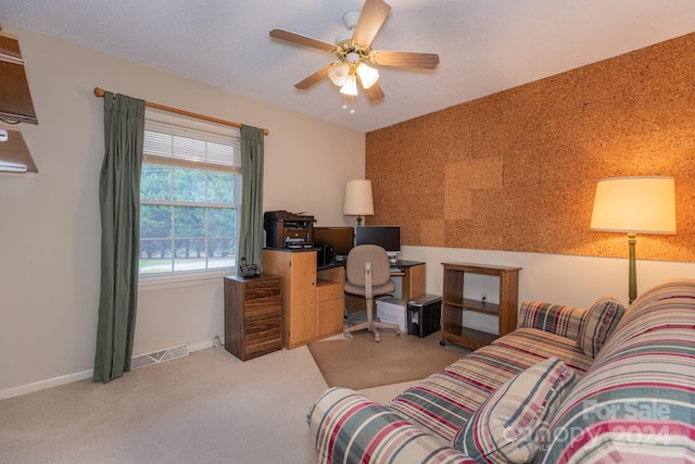 carpeted home office featuring ceiling fan