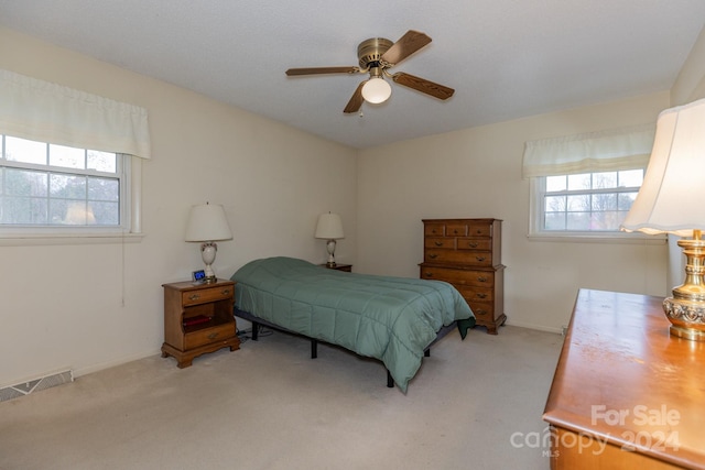 bedroom with ceiling fan and light carpet