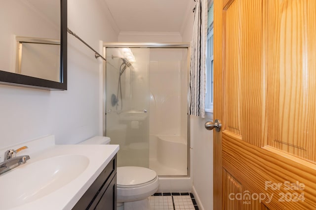 bathroom with a shower with door, crown molding, vanity, tile patterned flooring, and toilet