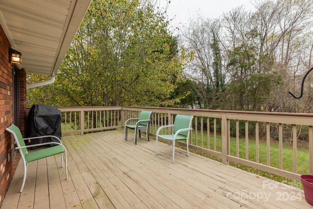 wooden terrace featuring area for grilling and a lawn