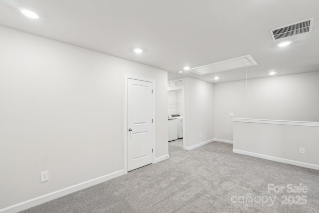 unfurnished room with washer / clothes dryer and light colored carpet