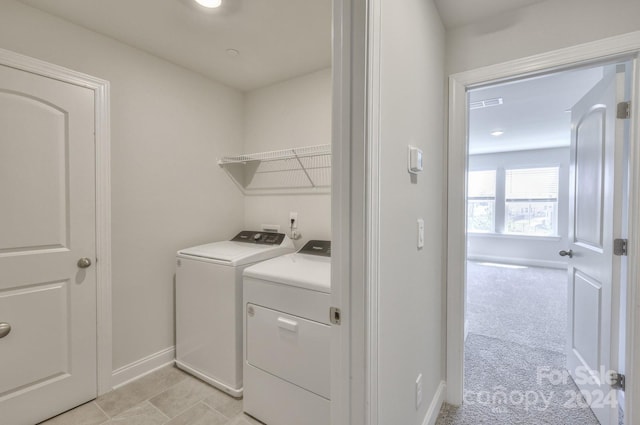 clothes washing area featuring washing machine and dryer and light carpet