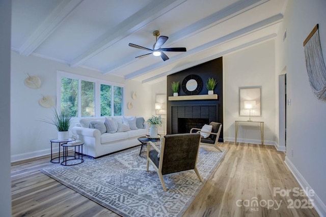 living room with a fireplace, vaulted ceiling with beams, hardwood / wood-style flooring, and ceiling fan