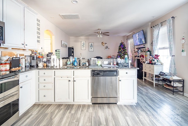 kitchen with kitchen peninsula, white cabinetry, dishwasher, and light hardwood / wood-style flooring