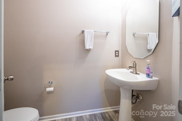 bathroom featuring hardwood / wood-style flooring and toilet