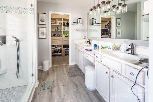 bathroom featuring hardwood / wood-style floors, vanity, and walk in shower