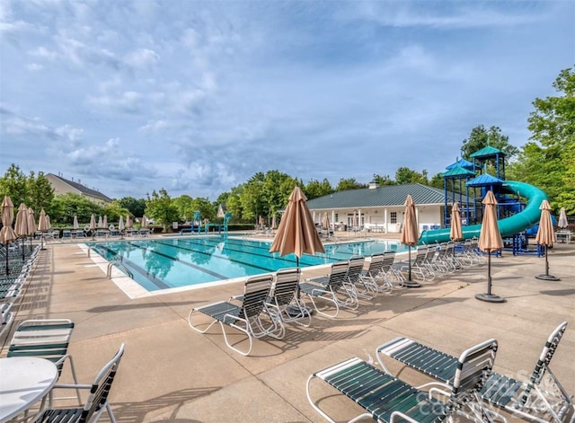 view of swimming pool with a patio and a water slide