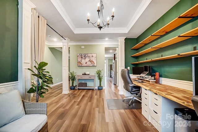 home office with an inviting chandelier, a raised ceiling, crown molding, and light hardwood / wood-style flooring