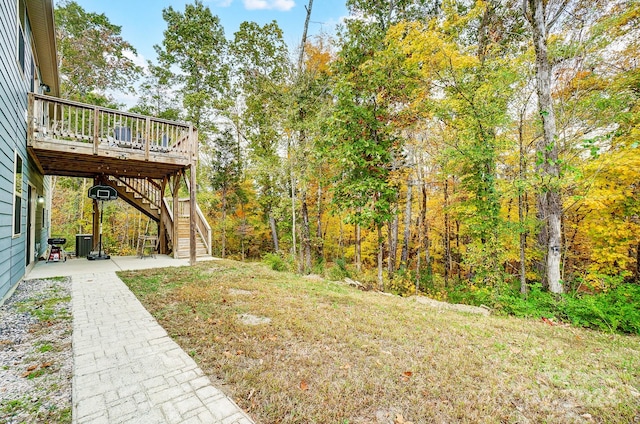 view of yard featuring a wooden deck and a patio