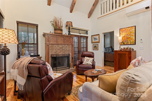 living room featuring a wall unit AC, plenty of natural light, beam ceiling, and light hardwood / wood-style flooring