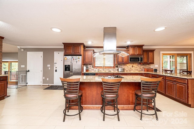 kitchen with a kitchen island, stainless steel appliances, light stone counters, and a breakfast bar