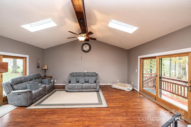 living room featuring wood-type flooring, ceiling fan, and lofted ceiling with skylight