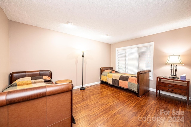 bedroom featuring dark wood-type flooring and a textured ceiling