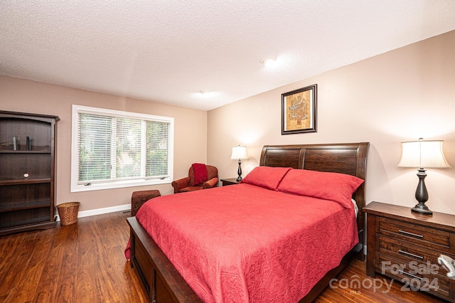 bedroom with dark wood-type flooring and a textured ceiling