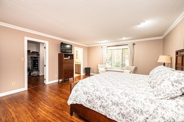 bedroom featuring a textured ceiling, dark hardwood / wood-style floors, crown molding, and connected bathroom