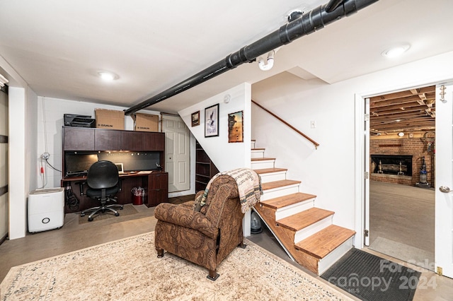 home office with a brick fireplace and concrete flooring