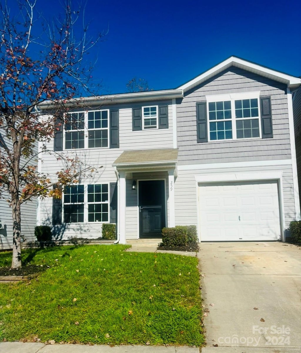 view of front of home with a front yard and a garage