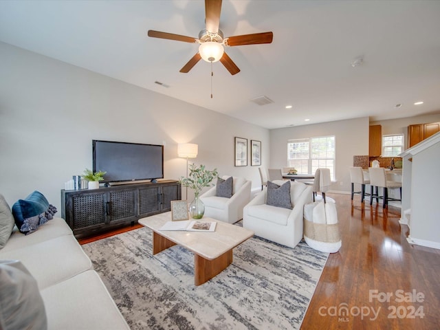 living room featuring ceiling fan and dark hardwood / wood-style floors