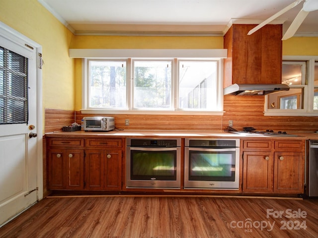 kitchen with decorative backsplash, stainless steel appliances, dark hardwood / wood-style floors, and crown molding