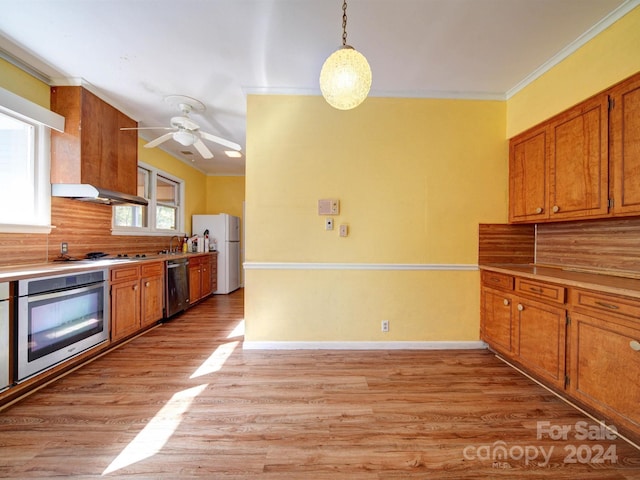 kitchen featuring decorative backsplash, appliances with stainless steel finishes, light hardwood / wood-style floors, and hanging light fixtures