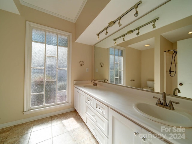 bathroom with toilet, vanity, tile patterned floors, and ornamental molding